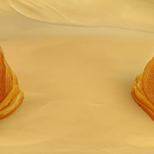 An empty table with the edges of two pastries just visible on either side, almost out of view.